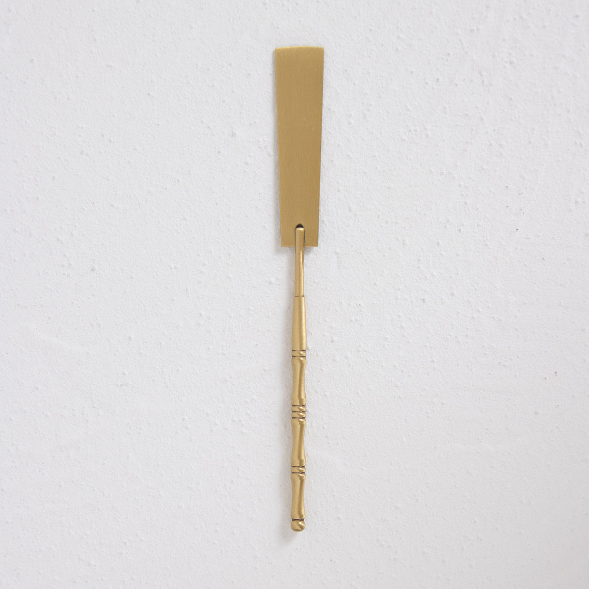 A bronze side ash press on a white surface, by Kin Objects