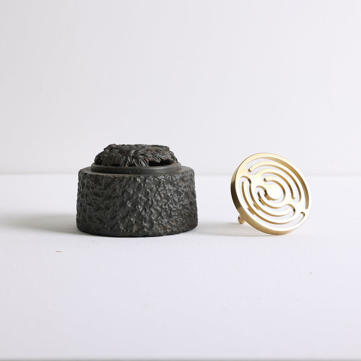 A cast iron incense burner and bronze mold for making incense seals