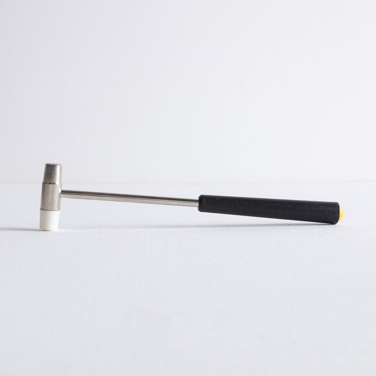 Side view of small mallet used with incense powder dropper