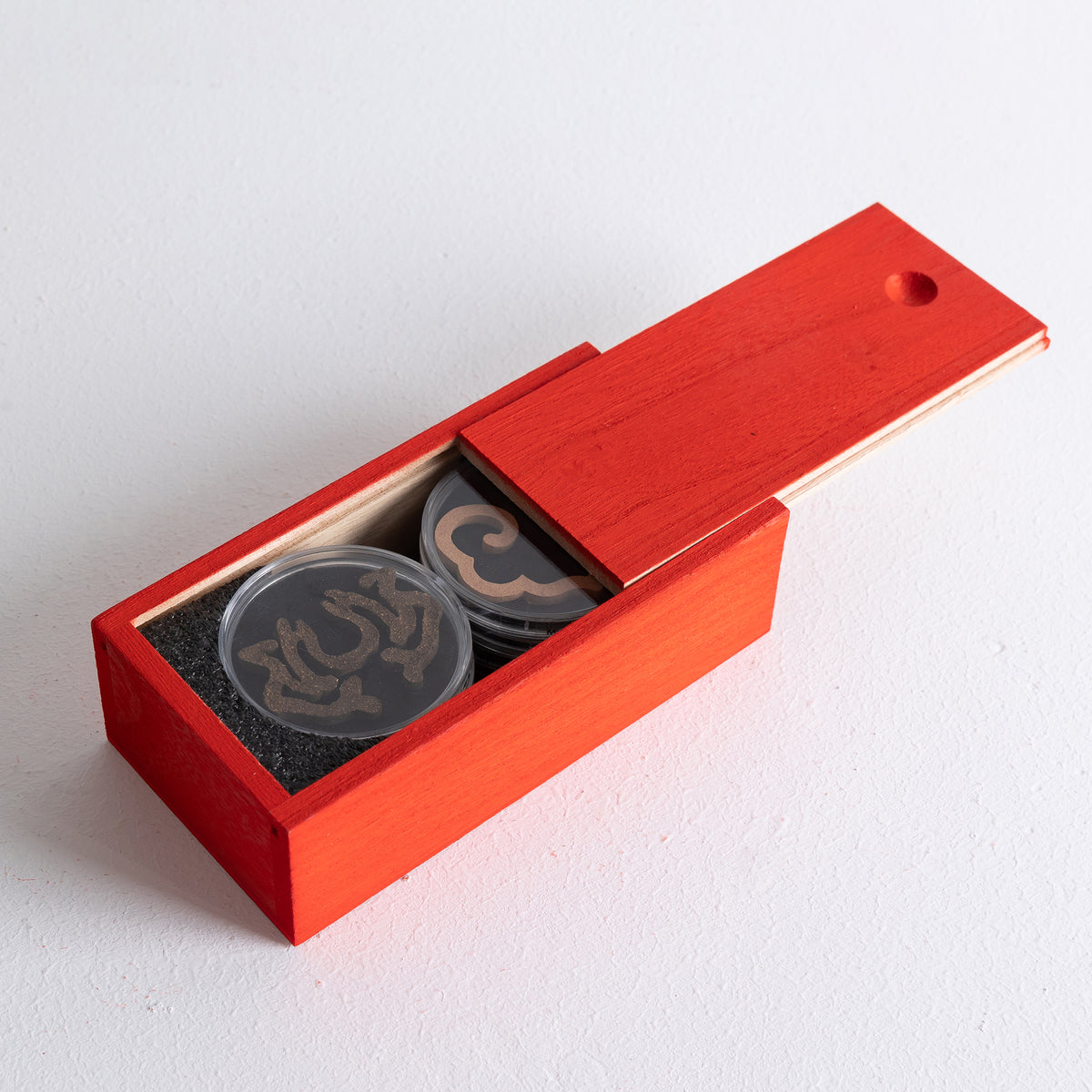 Set of 8 ready-made incense seals by Kin Objects displayed in a red wooden box