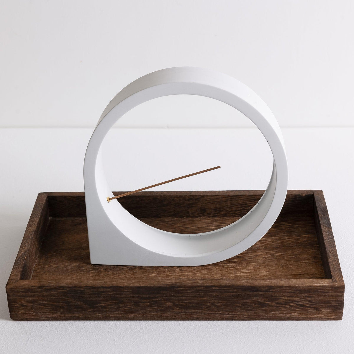 Front view of Kin Object's light gray Moon Grand incense burner in a wooden Tray