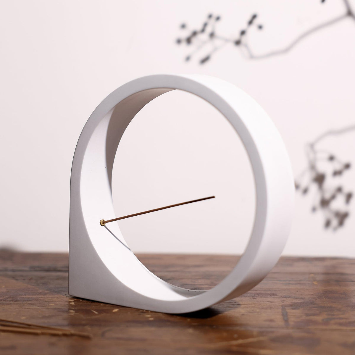 Angled view of light gray concrete incense holder on a table