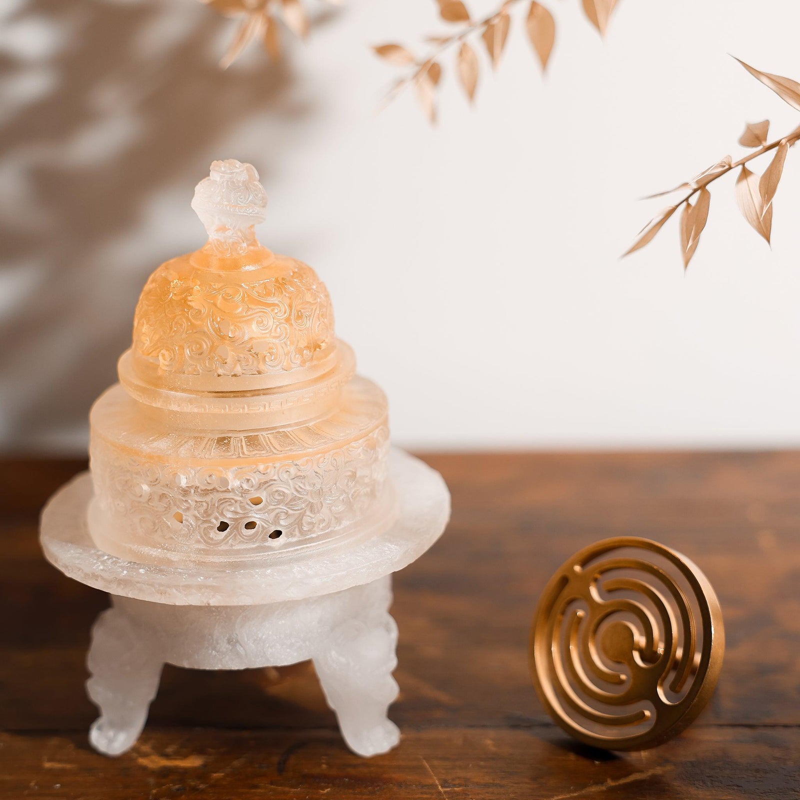 A liuli glass incense powder burner shows an amber glow after several uses