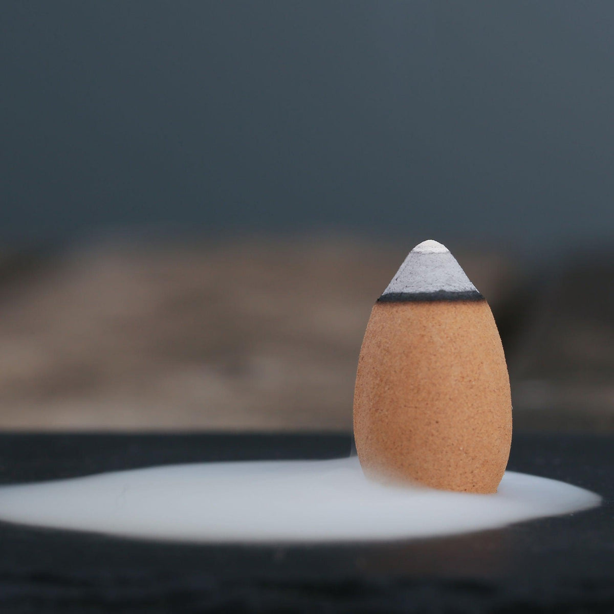 Backflow Incense Cones by Kin Objects Sitting On Table with Smoke Flowing out View 2