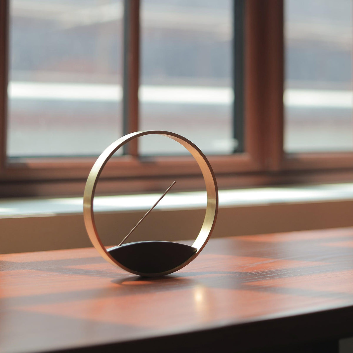 Moon Horizon bronze incense burner on a window sill