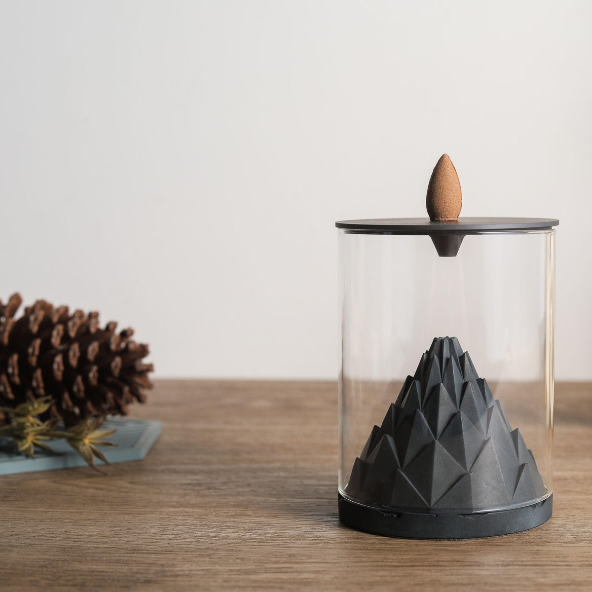 Modern concrete backflow incense burner on a wooden table