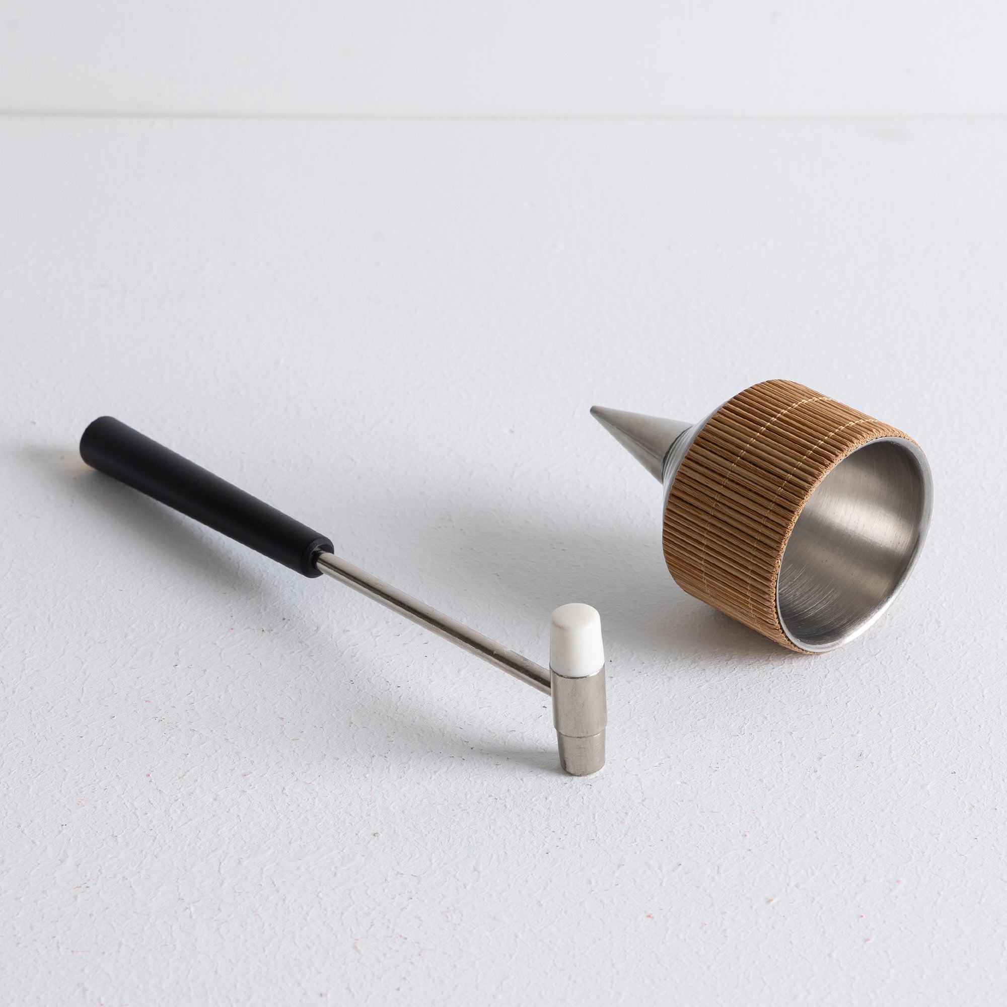 A powder incense set consisting of a metal dropper and small mallet, on a wooden tray