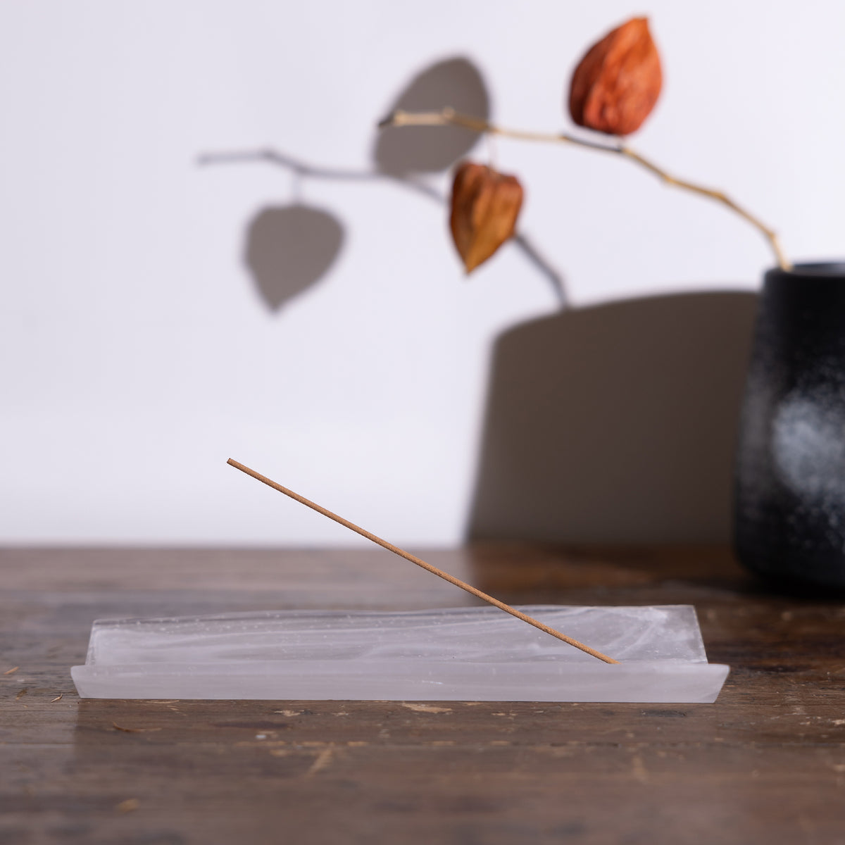 Side view of wood-patterned glass crystal incense burner on a table