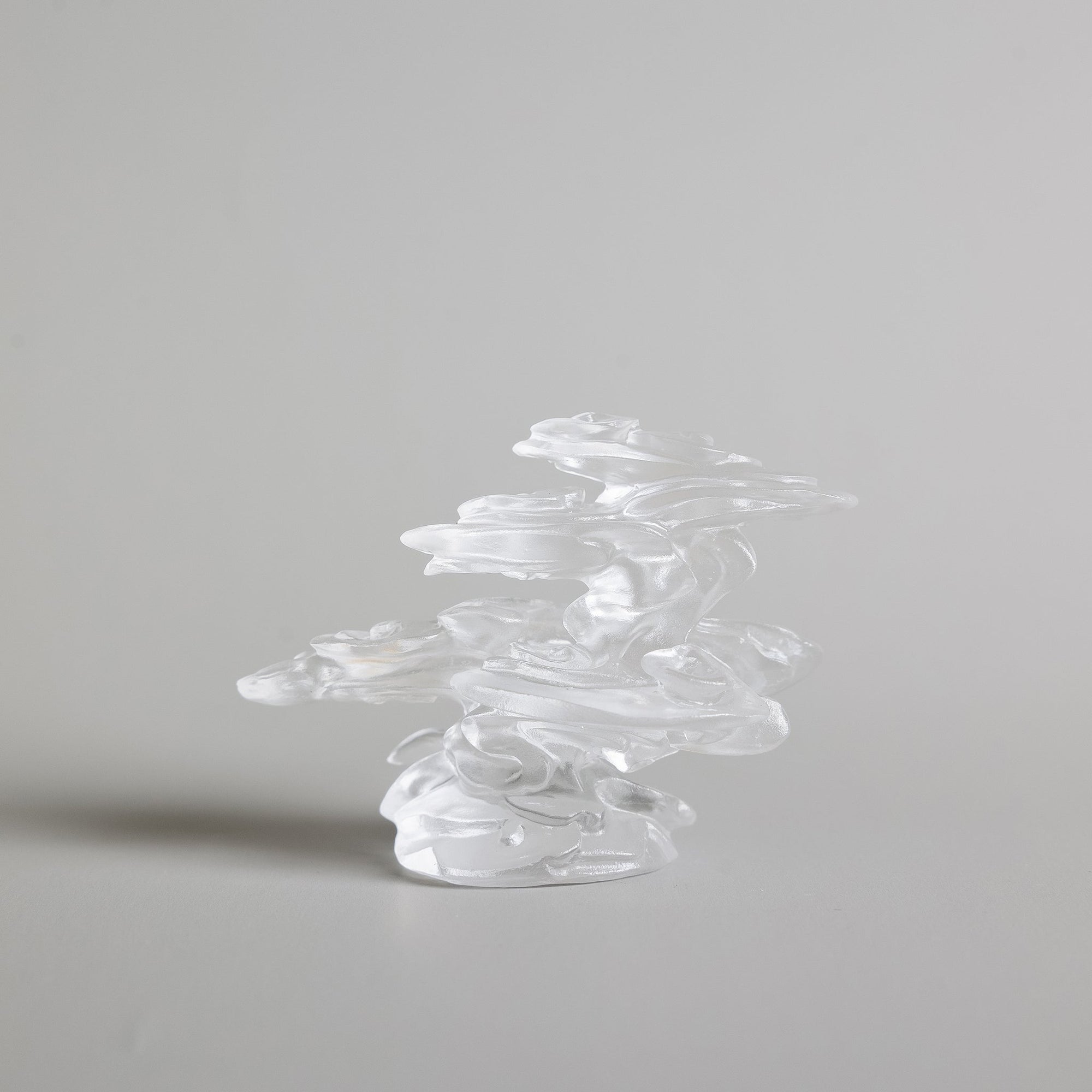 A burning incense stick in a cloud-inspired liuli crystal incense holder