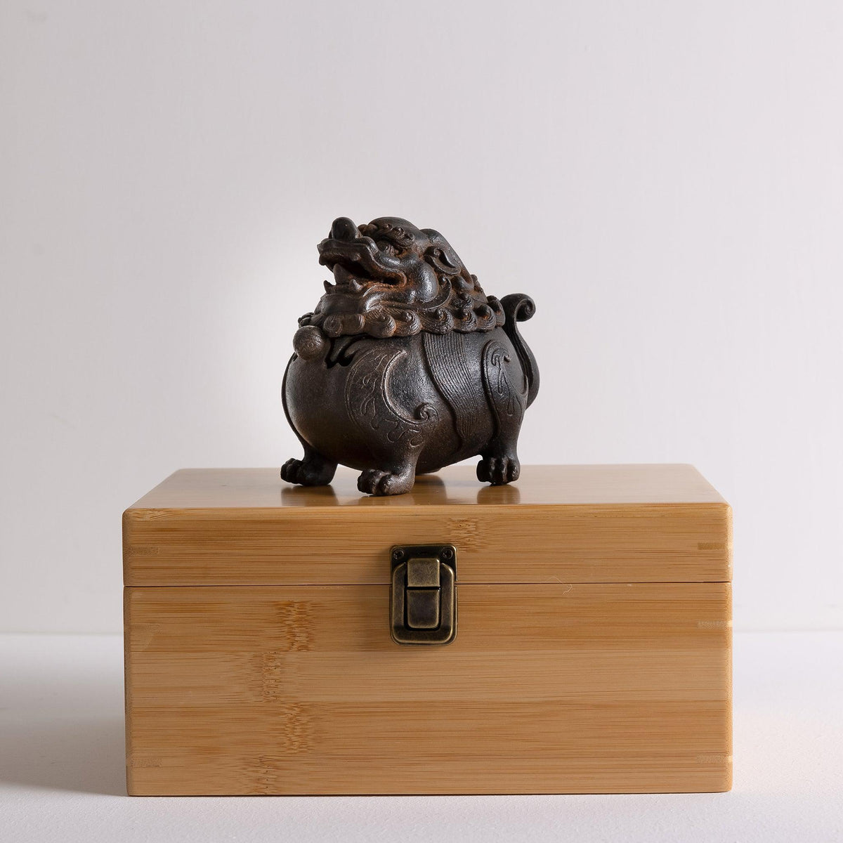 Cast iron suanni lion incense burner standing on bamboo box