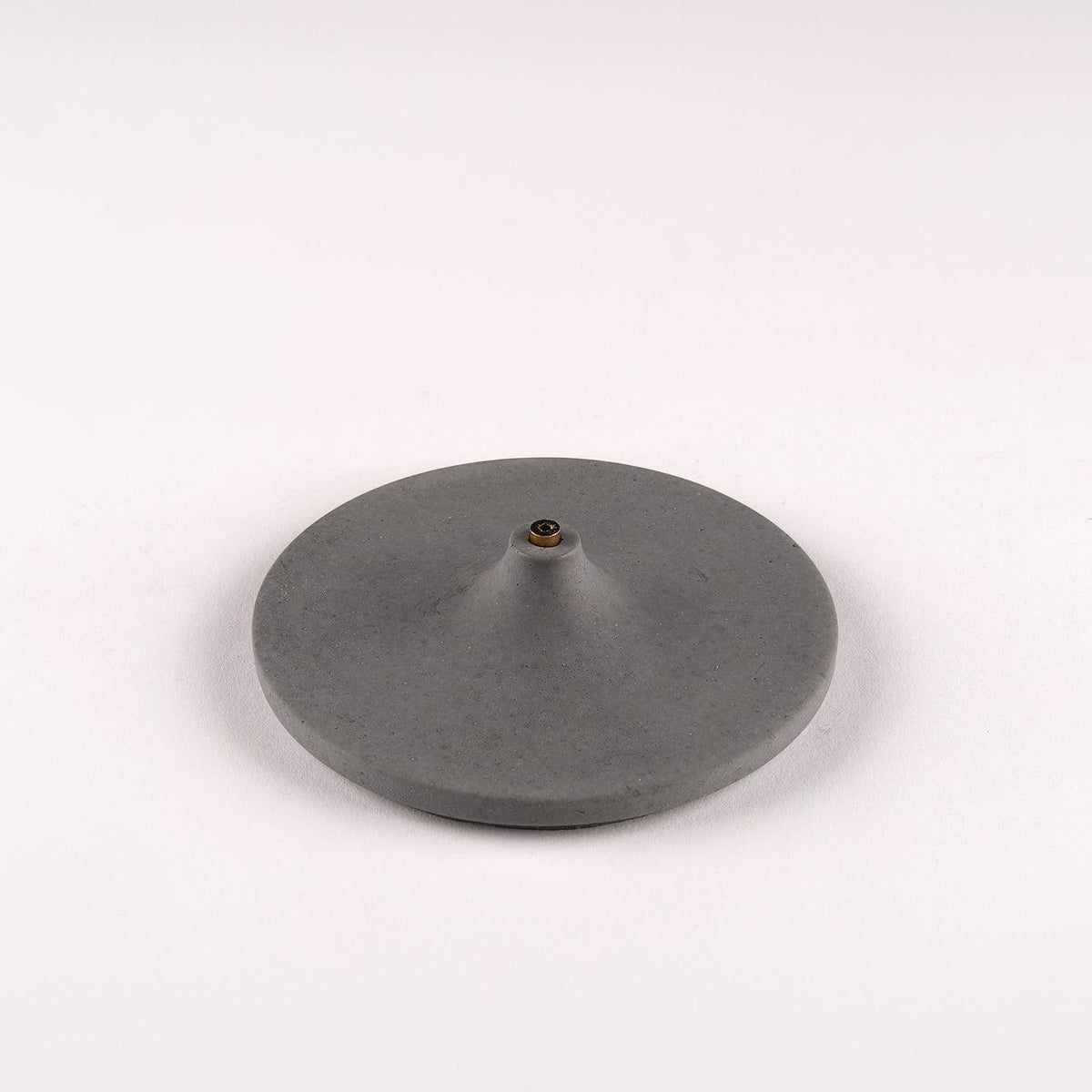 Close up of concrete incense holder Disk by Kin Objects