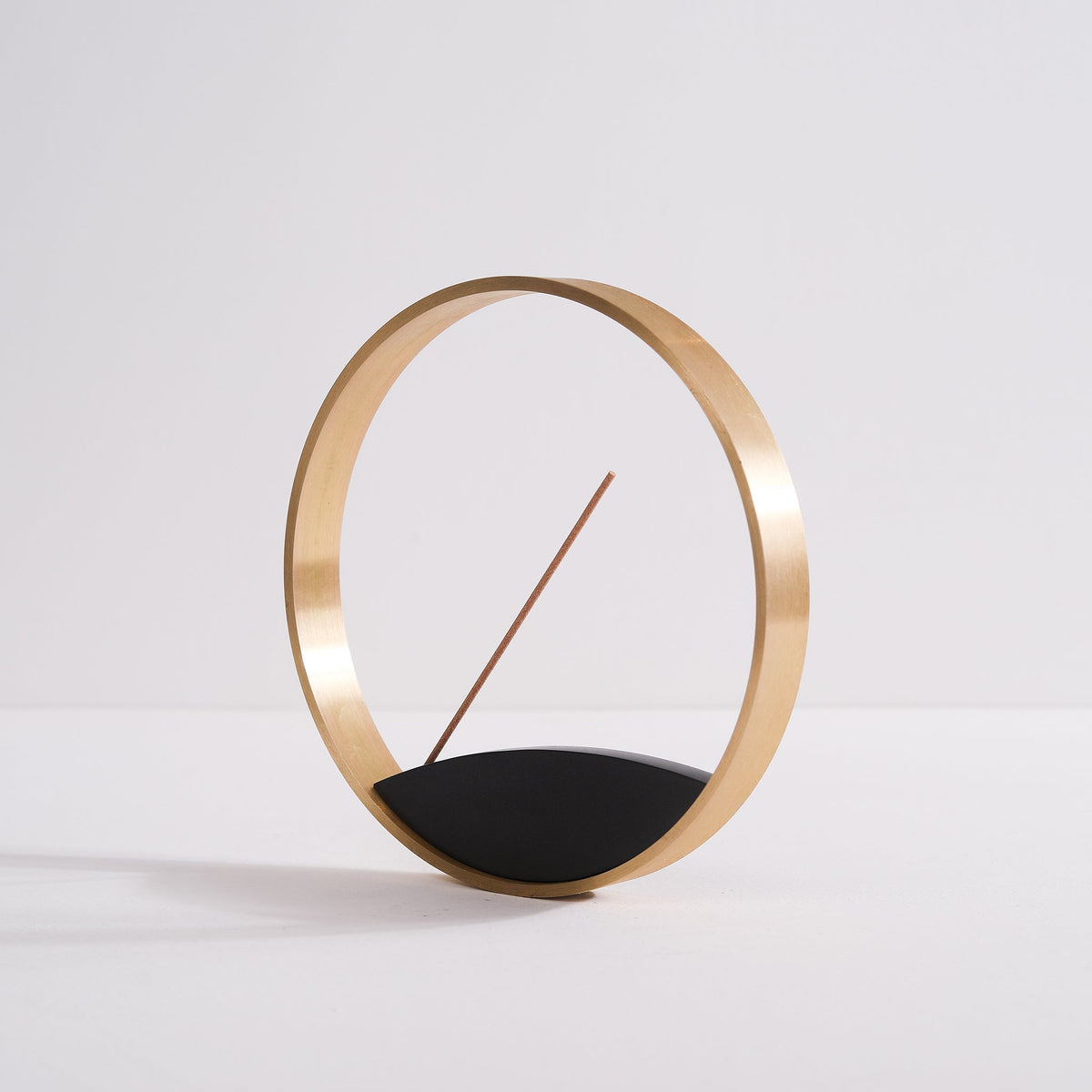 Angled view of modern circular incense holder made from bronze
