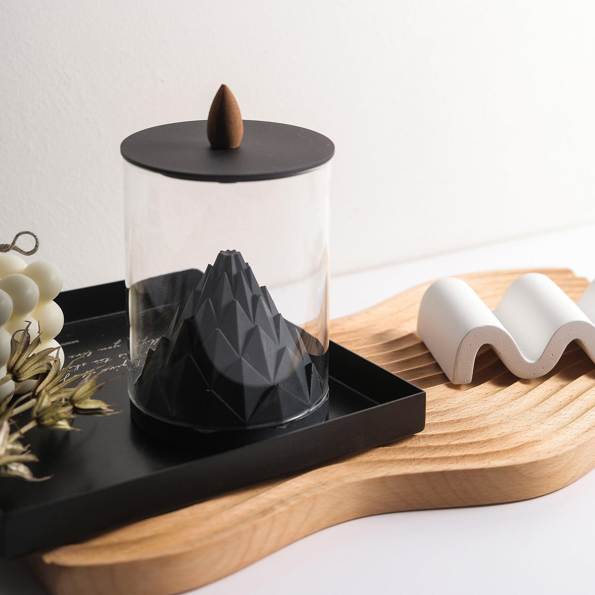 Nelumbo Terrarium Incense Fountain by Kin Objects on a wooden tray