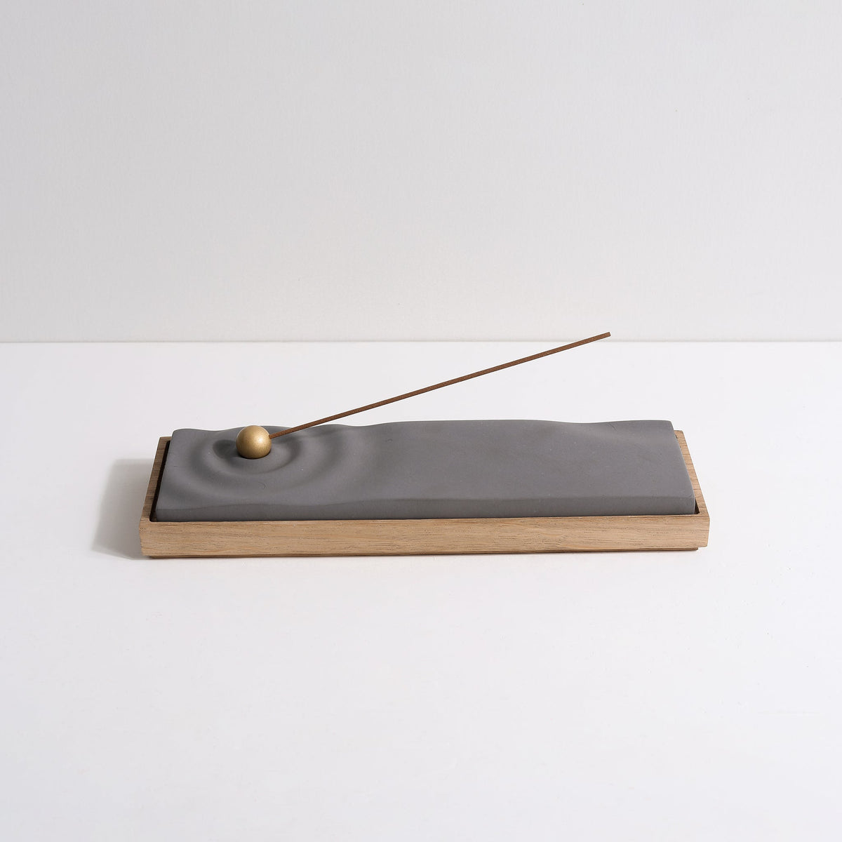 Concrete ripple incense burner with white oak base by Kin Objects
